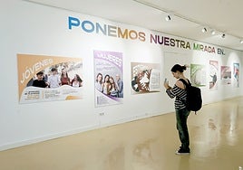 Una joven inmortaliza uno de los carteles de la exposición.