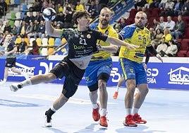 Isi Martínez, el central del Bathco, arma el brazo para el disparo mientras Juan Lumbreras, pivote del Caserío, intenta evitarlo.