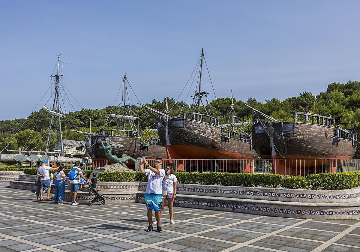 Un grupo de personas se fotografía con los galeones de Vital Alsar, que están muy deteriorados.