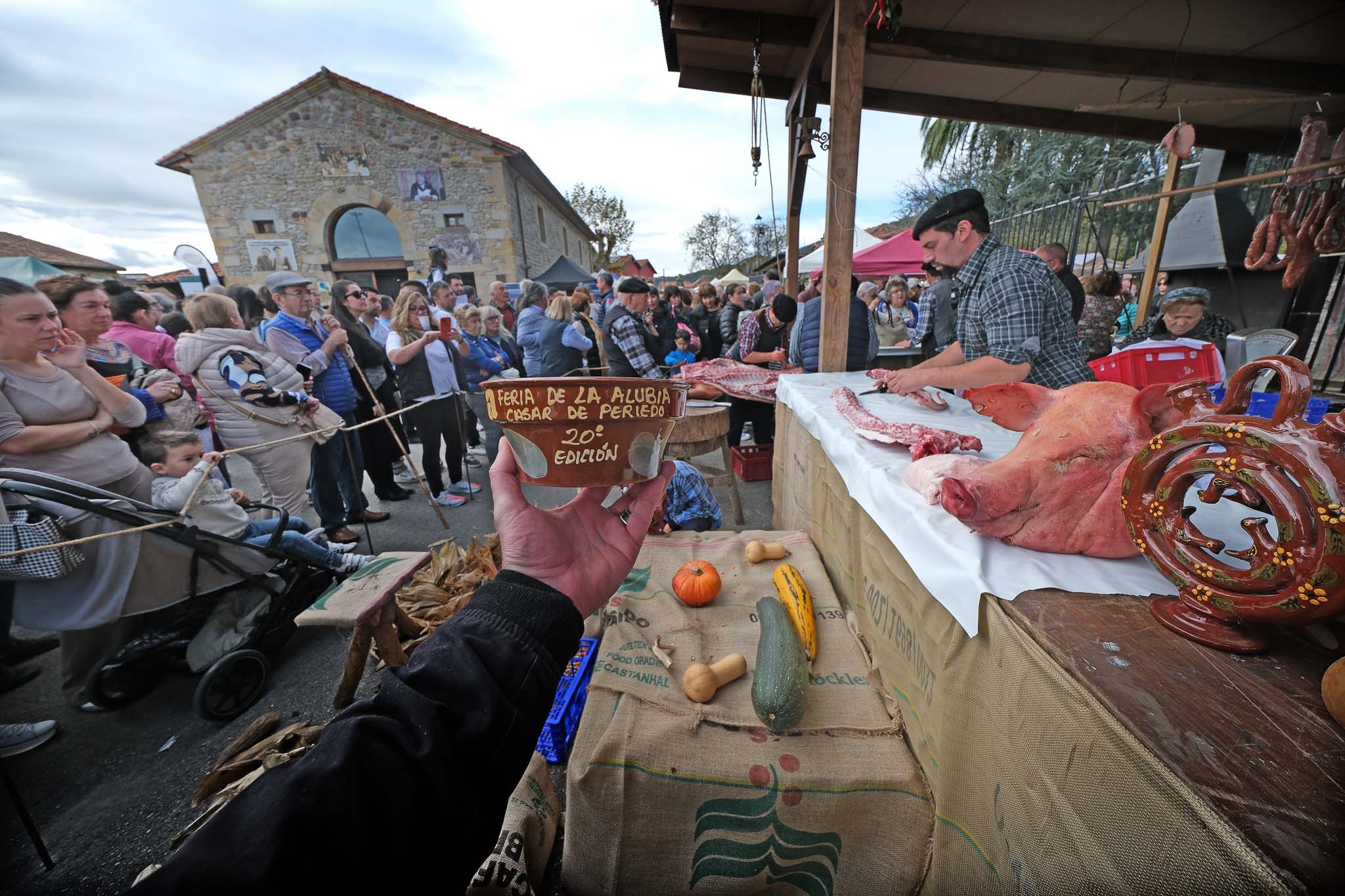 El tradicional bol donde se sirve el cocido montañés con la matanza del cerdo de fondo. 