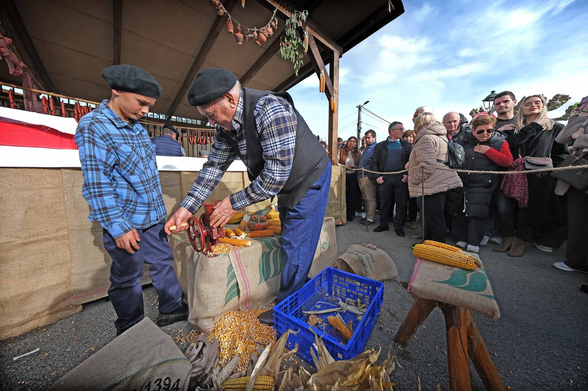 Un hombre apaña los chorizos y el maíz en el puesto.