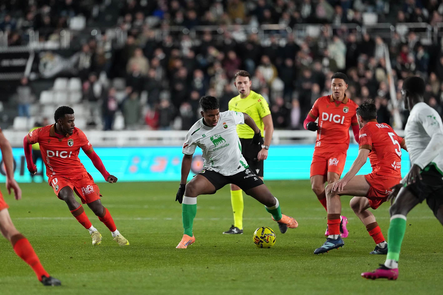 Jeremy, con el balón, rodeado entre jugadores del Burgos. 