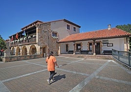 Una señora se acerca a la plaza del Ayuntamiento en Novales.