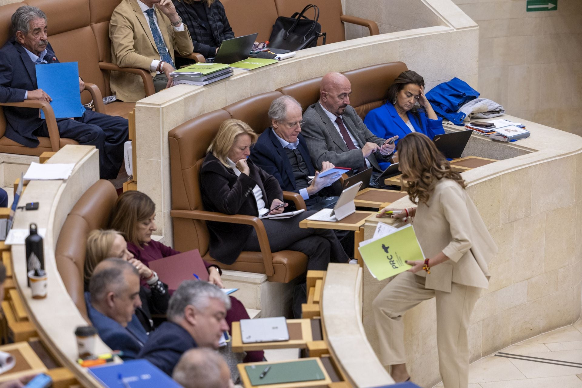 Fernández vuelve a su escaño tras defender la enmienda a la totalidad del PRC a las Cuentas. Mientras tanto, Buruaga mira sus notas.