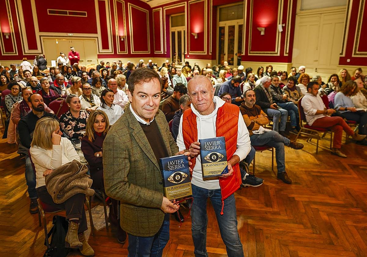 Javier Sierra y Miguel Blanco, presentador del acto, ante un salón repleto en el Casino de Barreda.