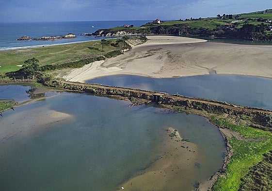 Dique a los pies de la playa de La Rabia, por la que se accede a través de esta polémica plataforma cuando hay bajamar.
