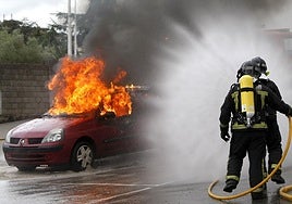Bomberos de Torrelavega apagan un vehículo envuelto en llamas en un simulacro.