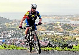 Un ciclista remonta una dura pendiente cerca de Barrionuevo, con el Abra al fondo.