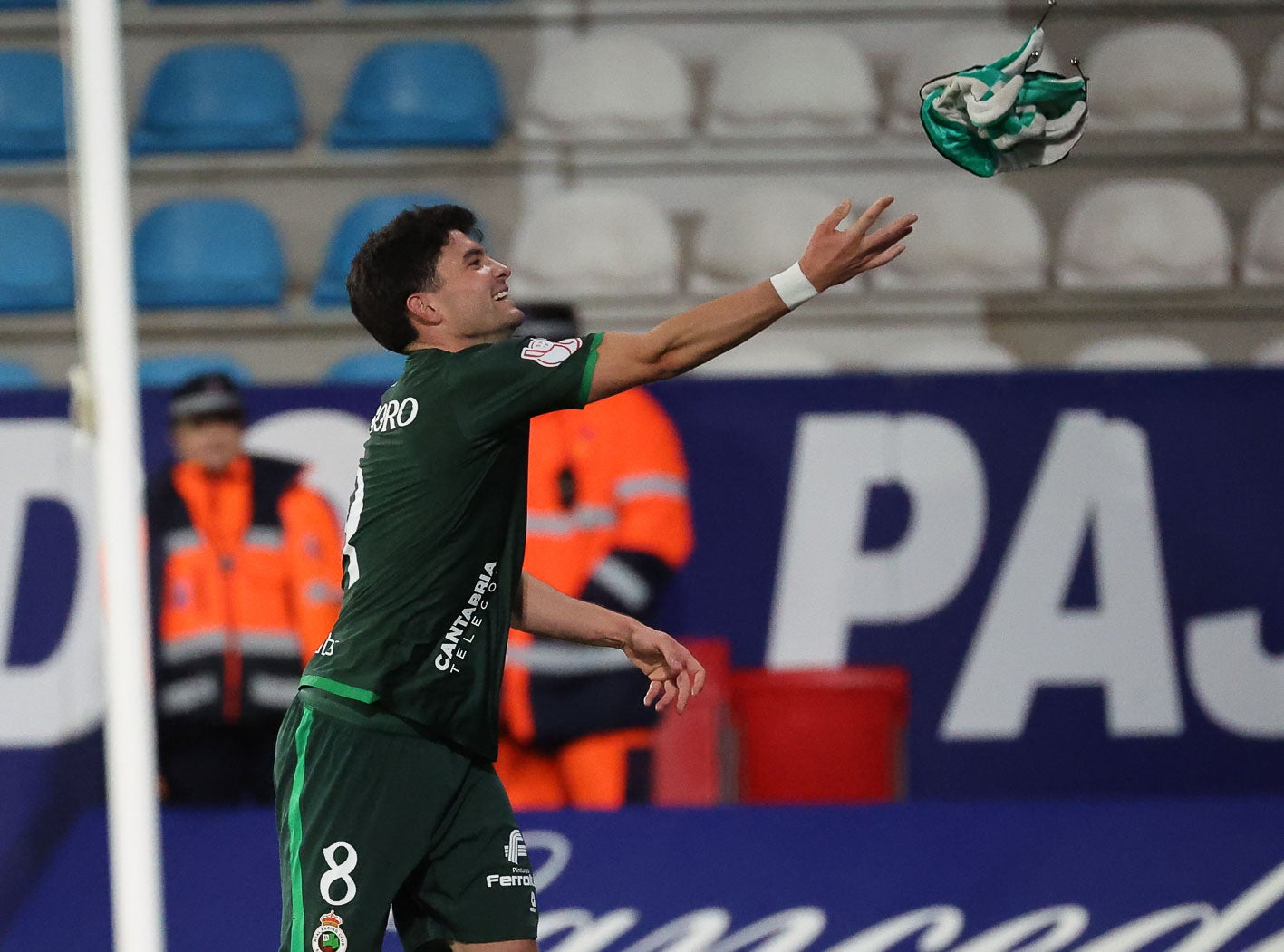 Aldasoro recoge un gorro del Racing que le habían lanzado unos aficionados. 