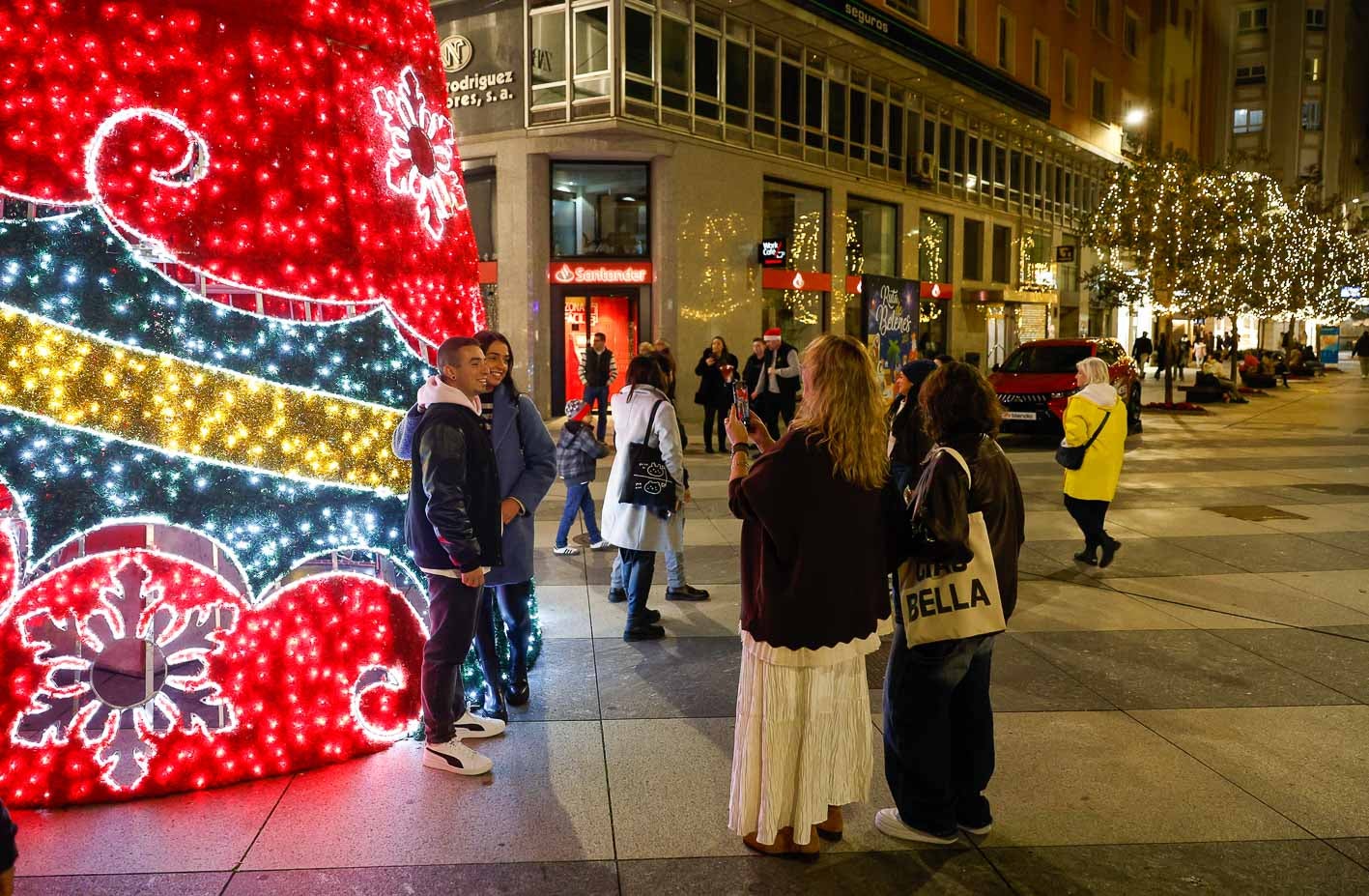 Dos jóvenes se toman una foto junto a las luces.