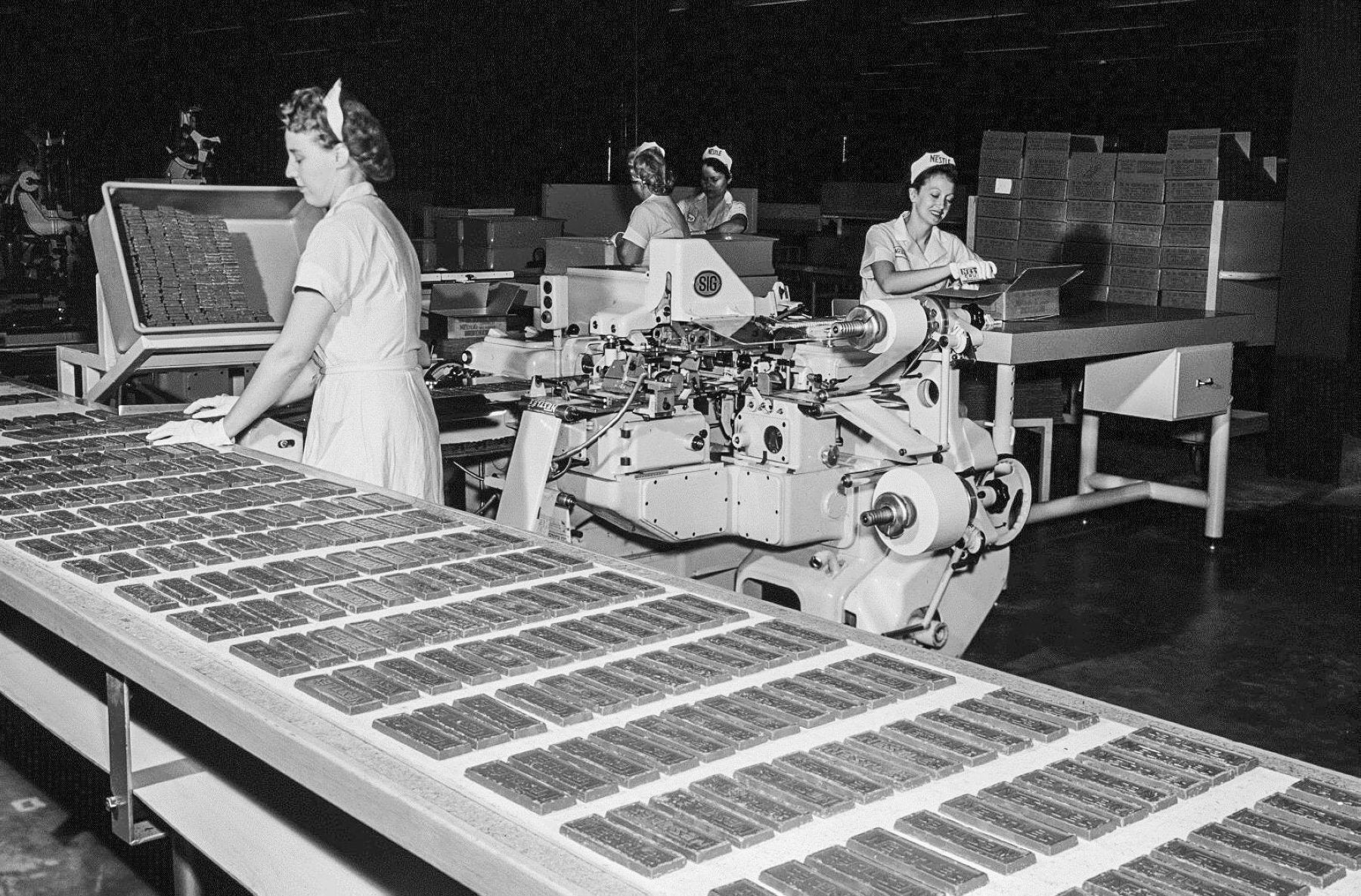 1961. Mujeres trabajando en la línea de preparación de tabletas de chocolate.