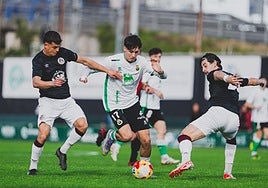 Santi Franco conduce la pelota entre dos rivales.
