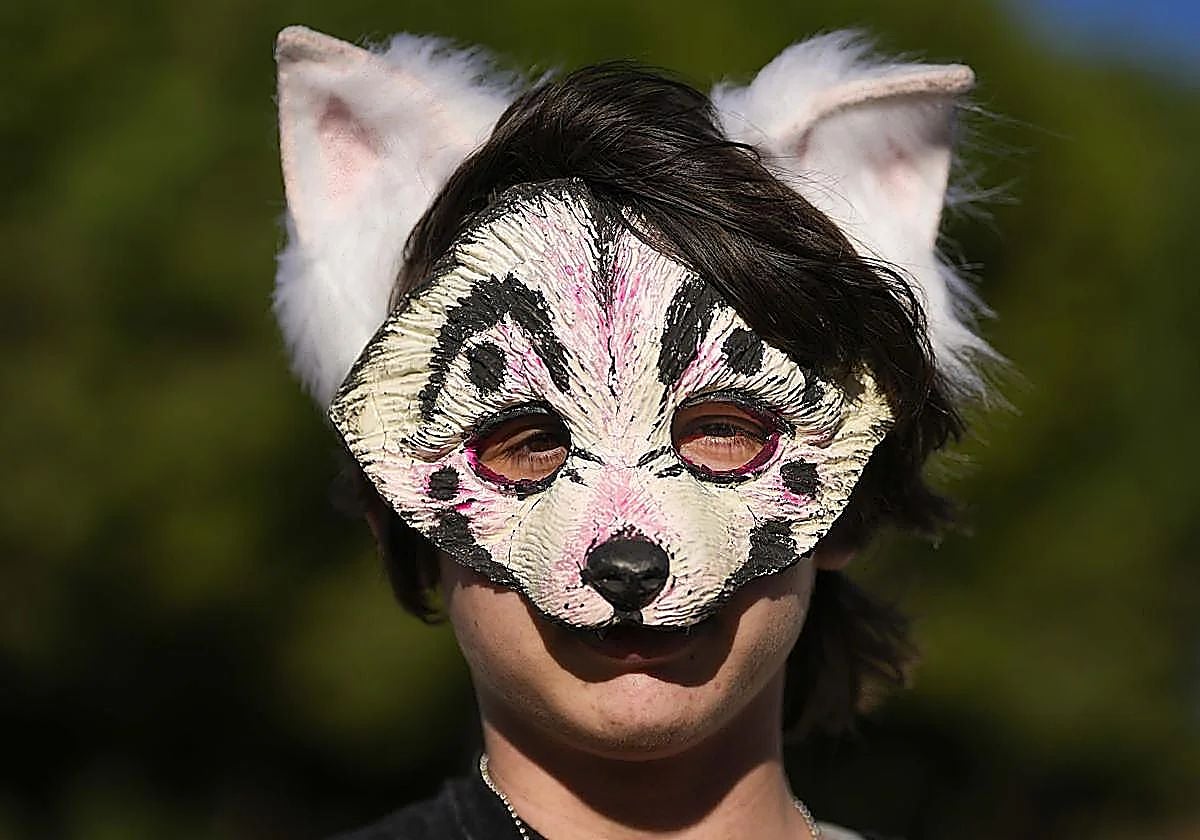 Un joven posa con máscara y orejas de perro.