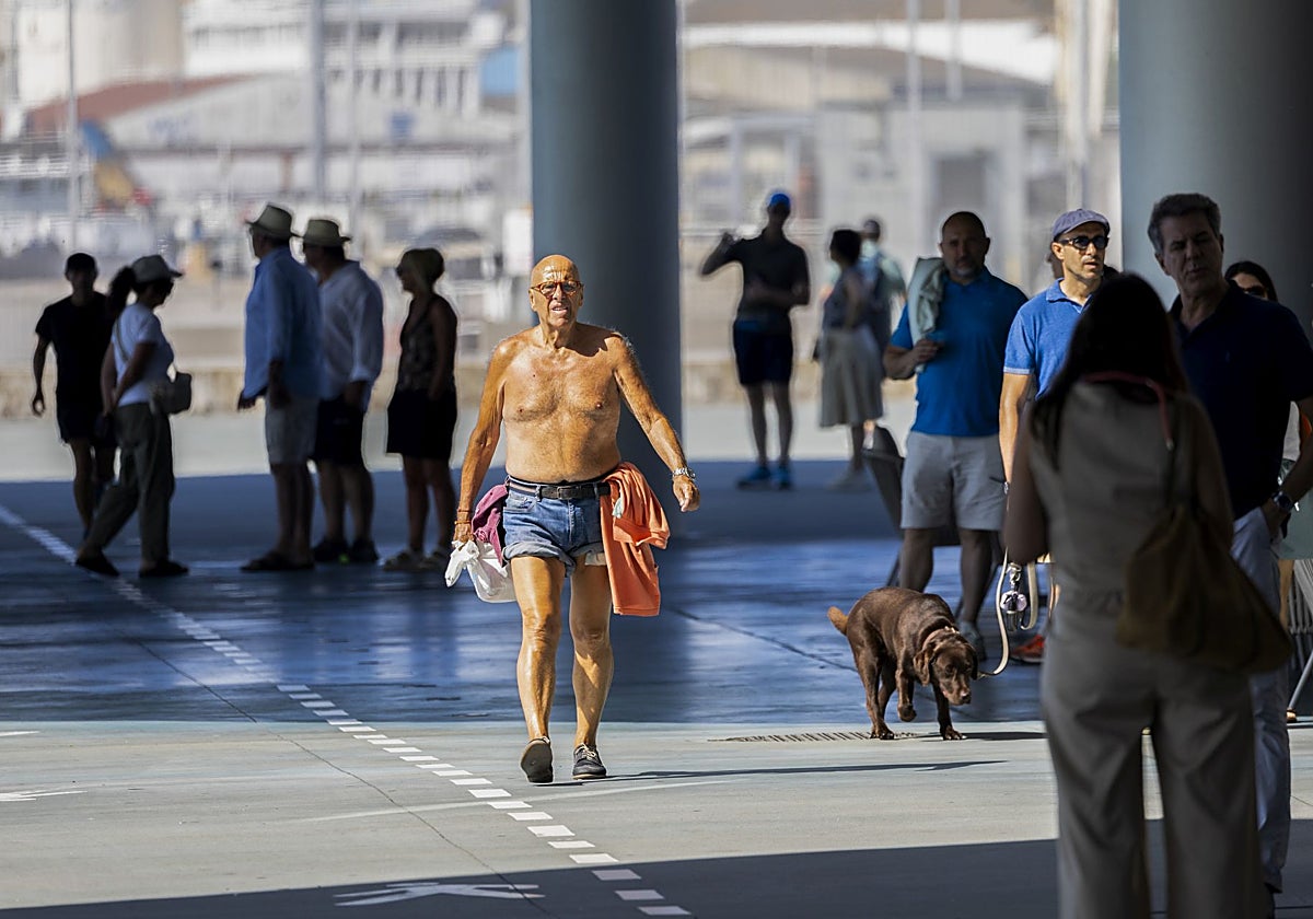 Un hombre pasea este lunes sin camiseta por los alrededores del Centro Botín.