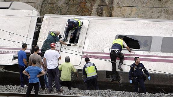 Bomberos y policias tratan de rescatar a las víctimas del accidente del tren Alvia. 