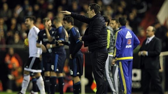 Gary Neville da instrucciones con Rafa Benítez al fondo. 