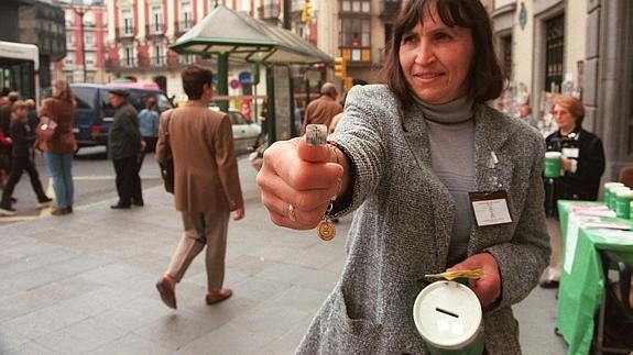 Una mujer recauda fondos para la Asociación Española Contra el Cáncer. 