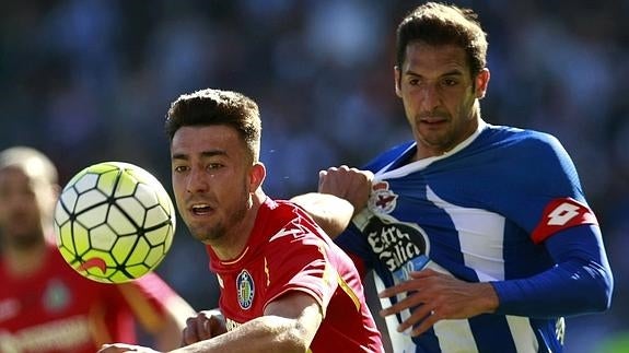 Miguel Ángel (i) disputa un balón con Celso Borges (d). 