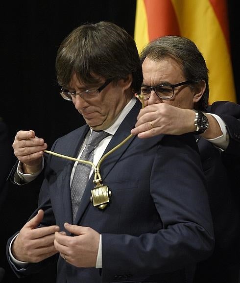 Artur Mas impone la medalla representativa del cargo a Carles Puigdemont durante la toma de posesión de este último. 