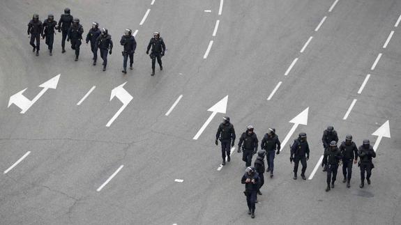 Grupo de policías andando por una carretera.