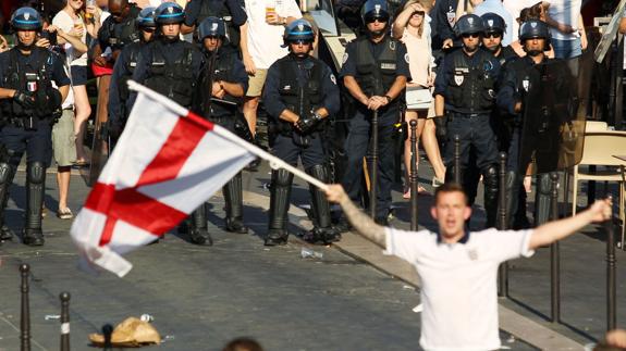 La policía custodia detrás de los aficionados ingleses. 