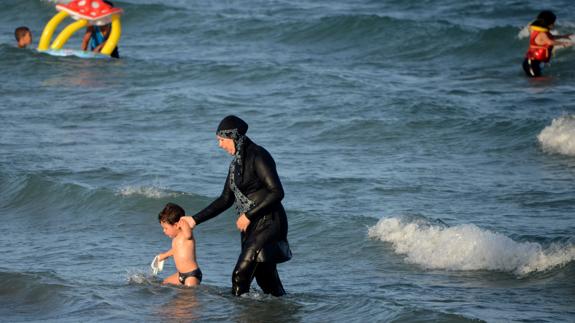 Una mujer musulmana se baña en la playa con 'burkini'.