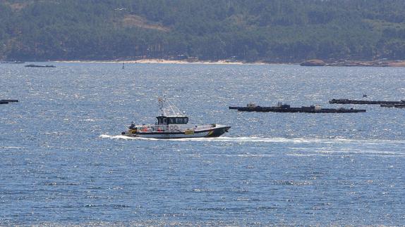 Una patrullera de la Guardia Civil rastrea la costa frente a la playa de Cabío, en A Pobra do Caramiña (La Coruña).