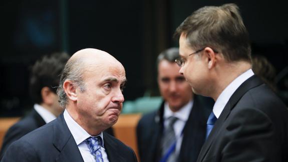 Luis de Guindos (i) conversa con el vicepresidente de la Comisión Europea para el Euro, Valdis Dombrovskis.