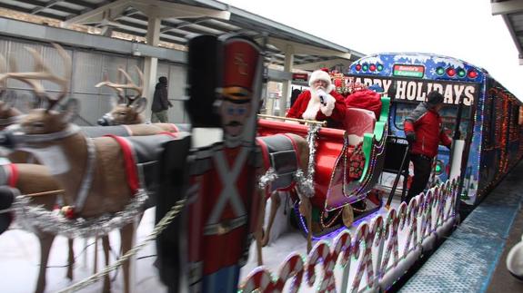 Papá Noel saluda a los turistas desde su trineo.