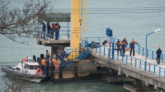 Los equipos de rescate trasladan los cuerpos.