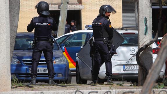 Dos policías aguardan frente al edificio del atrincherado. 