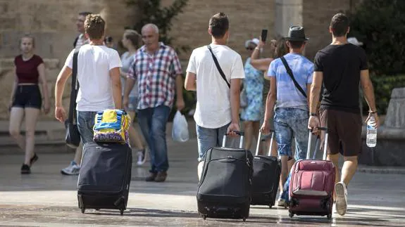 Tres turistas con maletas en Valencia.