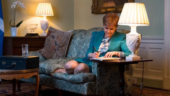 La líder escocesa Nicola Sturgeon escribe la carta que le ha enviado este viernes a Theresa May. EFE