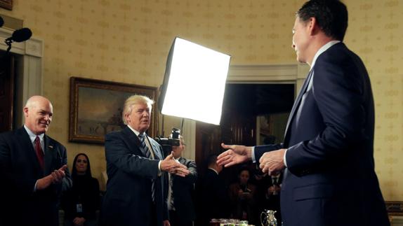 Donald Trump y James Comey se dan la mano.