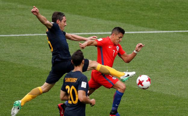 Alexis Sánchez trata de marcharse de dos futbolistas de Australia. 