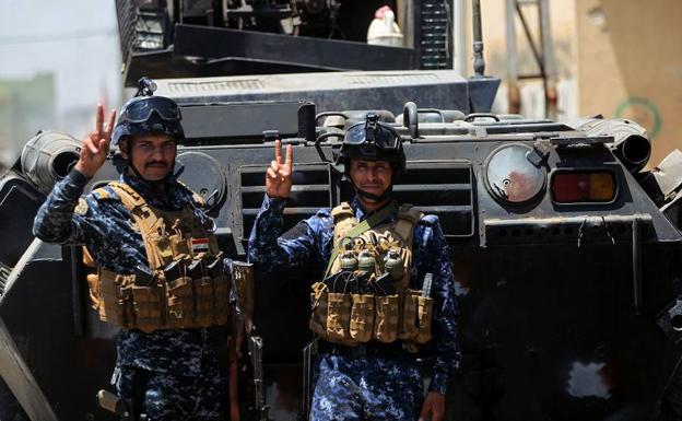 Dos soldados iraquíes celebran la conquista de un barrio de Mosul.