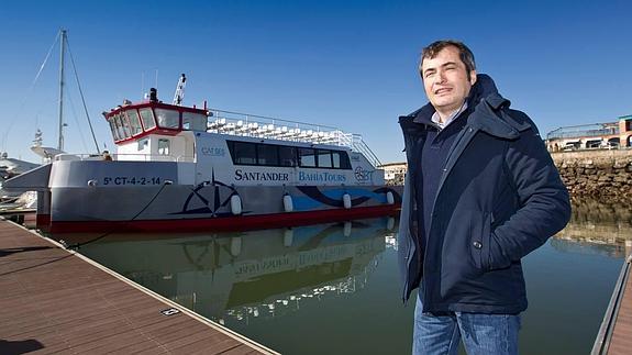 Enrique Arriola, junto a su embarcación atracada en el puerto deportivo Marina del Cantábrico, a la espera de navegar por la bahía.