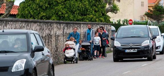 Grupo de padres y alumnos del colegio Manuel Cacicedo regresan a sus casas por la carretera sin aceras del barrio Corceño. 