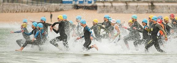 Los 130 participantes en el Triatlón de Santander comienzan la prueba lanzándose al agua en El Sardinero.