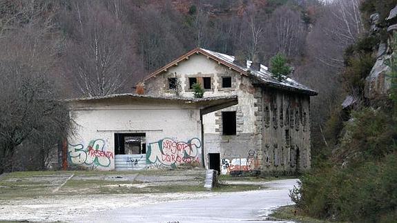 Muelle cubierto y, detrás, edificio de viajeros de la estación de La Engaña, los dos inmuebles que entran en el contrato inicial firmado por la cooperativa ecofeminista que quiere rehabilitarlos.