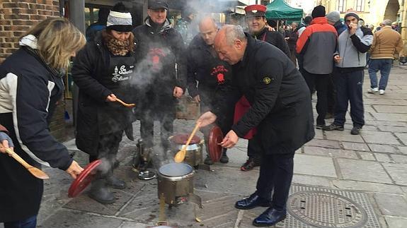 El alcalde, José Miguel Barrio, remueve el contenido de una olla ferroviaria con una cuchara de palo.