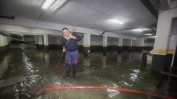 El mar entró en los garajes de uno de los bloques de García Lago. Un operario achicaba agua desde primera hora.