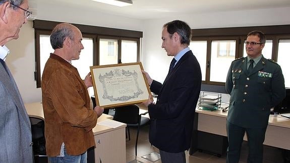 Momento en el que el Delegado del Gobierno entrega el diploma a Garay.