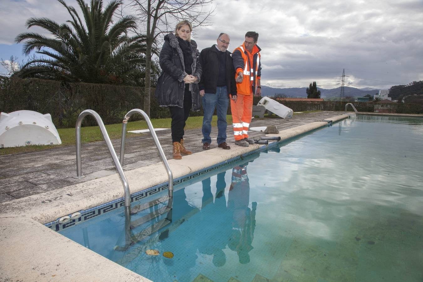 La alcaldesa de Camargo junto al concejal de Servicios Públicos y un operario, al borde de la piscina de Igollo.