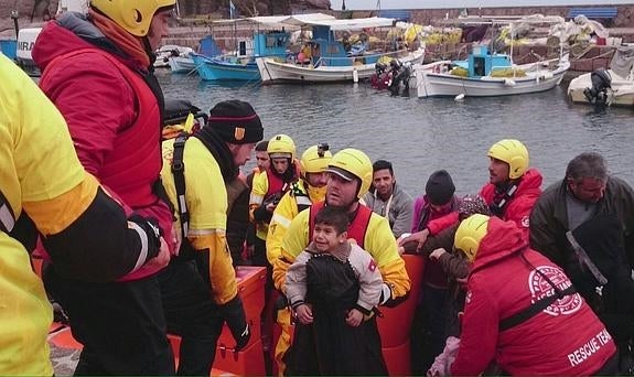 Cooperantes de la ONG Proactiva Open Arms ayudan a desembarcar a los refugiados recién llegados a Lesbos. 