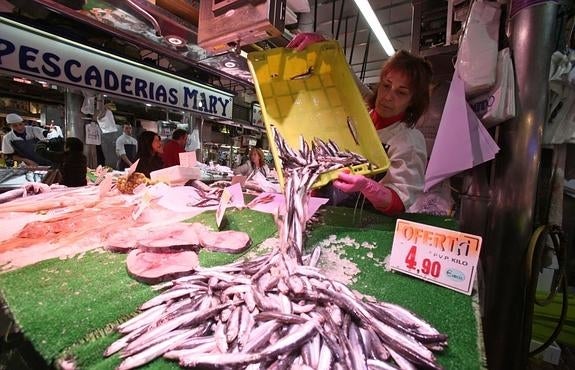 Una de las pescaderas del Mercado de la Esperanza repone el bocarte en su puesto . 
