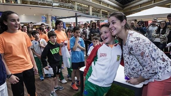 Carolina Marín se fotografía con un joven jugador de bádminton de la escuela de Torrelavega.