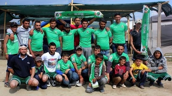 Refugiados de todos los países posan con las camisetas del Racing antes del partido.