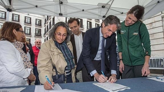 Íñigo de la Serna firma para apoyar la candidatura de Ruth Beitia, a su izquierda, para el premio Princesa de Asturias de los Deportes 2016. 