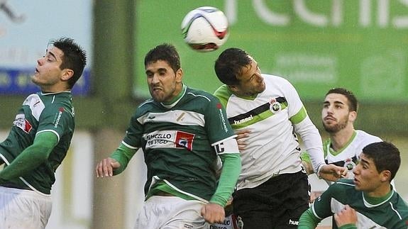 Caneda salta a por el balón con un contrario en el partido de la primera vuelta ante el Coruxo.